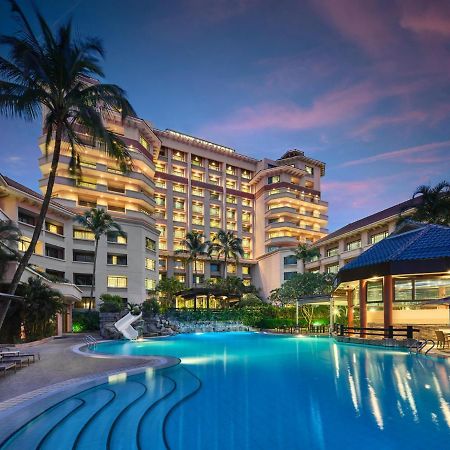Paradox Singapore Merchant Court At Clarke Quay المظهر الخارجي الصورة The photo shows a luxurious hotel building, featuring multiple stories and a modern architectural design. In front of the hotel, there is a large, inviting swimming pool that is illuminated in a vibrant blue hue, suggesting it may be an evening setti