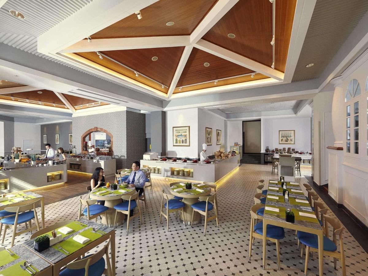 Paradox Singapore Merchant Court At Clarke Quay المظهر الخارجي الصورة The photo depicts a modern restaurant interior. The space features a stylish design with a high ceiling and wooden details, creating an inviting atmosphere. 

Tables are neatly arranged, each set with green placemats and blue chairs. There is a secti
