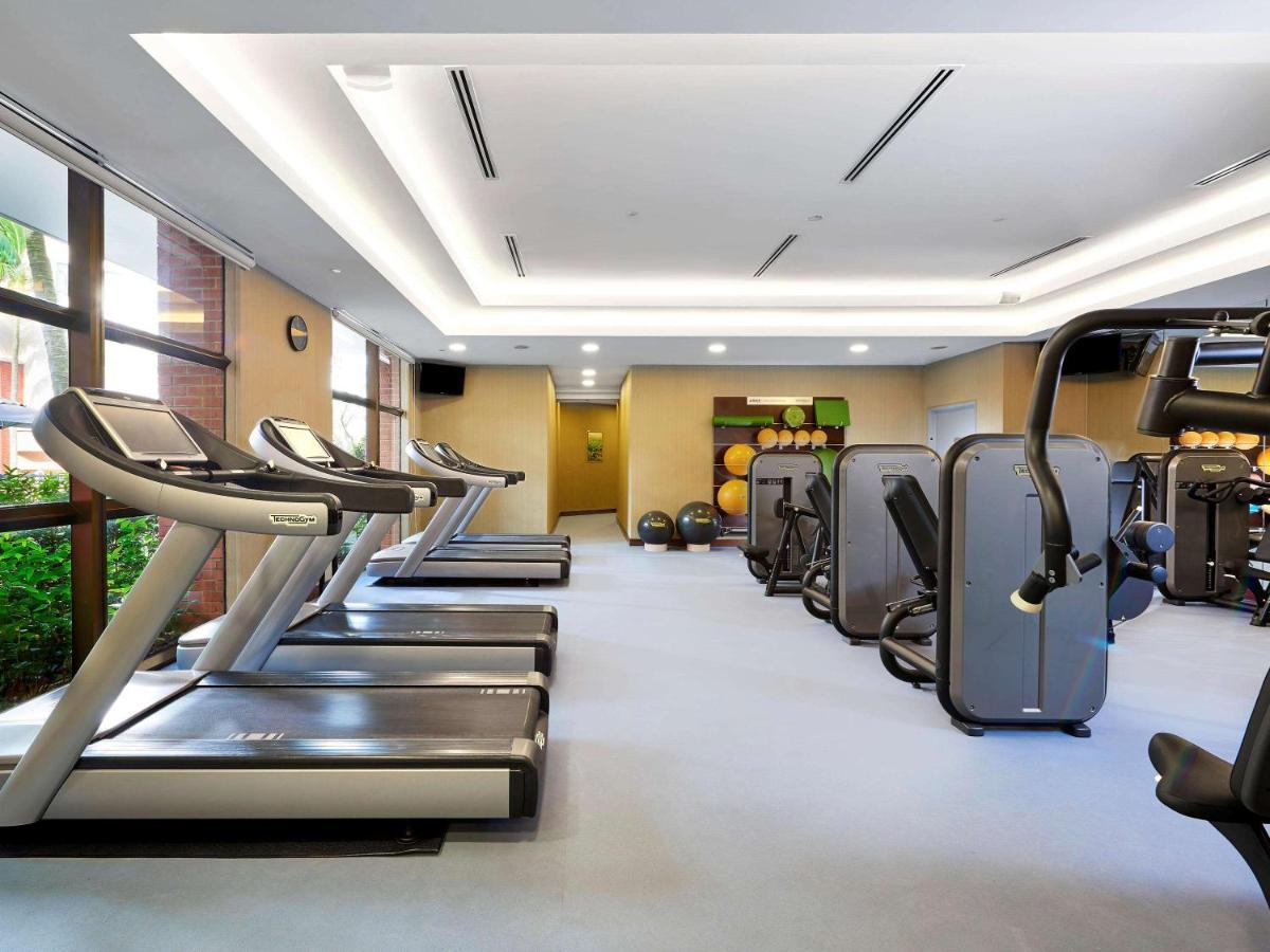 Paradox Singapore Merchant Court At Clarke Quay المظهر الخارجي الصورة The photo shows a fitness gym interior that features several exercise machines and equipment. There are three treadmills positioned next to a large window, allowing natural light to enter the space. Alongside the treadmills, various types of strength