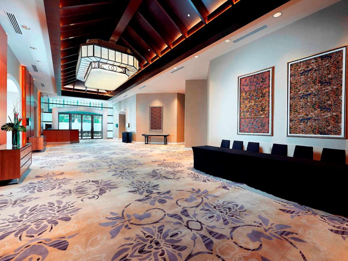 Paradox Singapore Merchant Court At Clarke Quay المظهر الخارجي الصورة The photo depicts a spacious and elegantly designed lobby area. The ceiling features a distinctive wooden design with soft lighting. On the walls, there are large decorative art pieces that add to the aesthetic appeal. The floor is covered with a pat