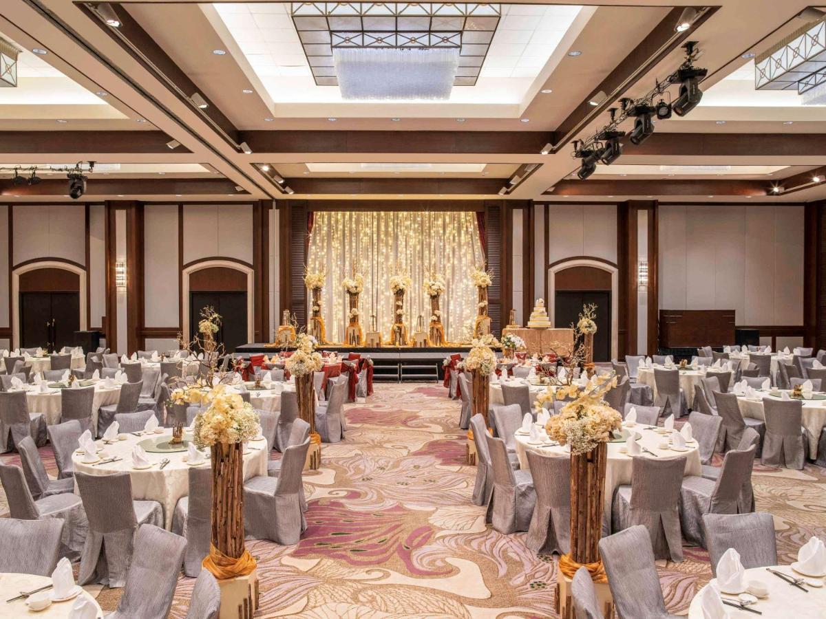 Paradox Singapore Merchant Court At Clarke Quay المظهر الخارجي الصورة The photo depicts an elegant banquet hall set up for an event. The room features numerous round tables draped in white and gray tablecloths, each adorned with floral centerpieces. The chairs are covered in gray fabric with white accents. At the front