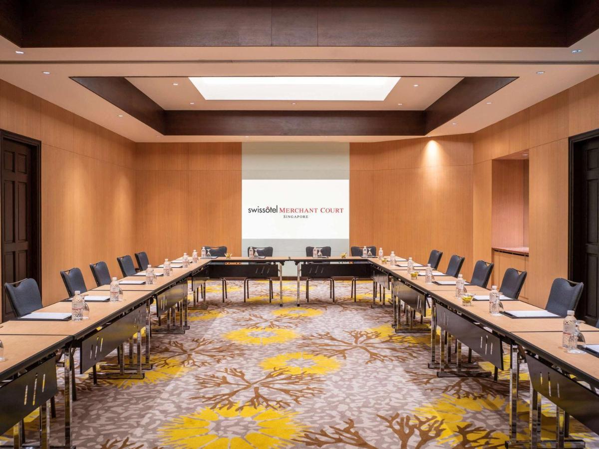 Paradox Singapore Merchant Court At Clarke Quay المظهر الخارجي الصورة The image shows a professional conference room designed for meetings. It features a large rectangular arrangement of tables with black chairs surrounding them. The walls are made of light-colored wood, contributing to a modern and sophisticated atmos