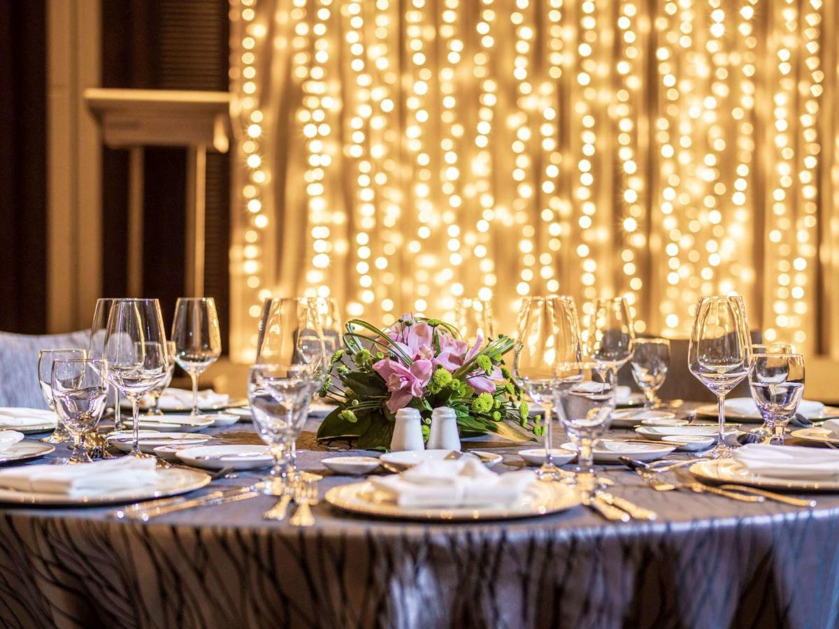 Paradox Singapore Merchant Court At Clarke Quay المظهر الخارجي الصورة The image shows a beautifully set dining table, elegantly arranged for a special event or celebration. The table is covered with a stylish cloth, and there are several plates, glasses, and utensils neatly placed around it. In the center, there's a fl