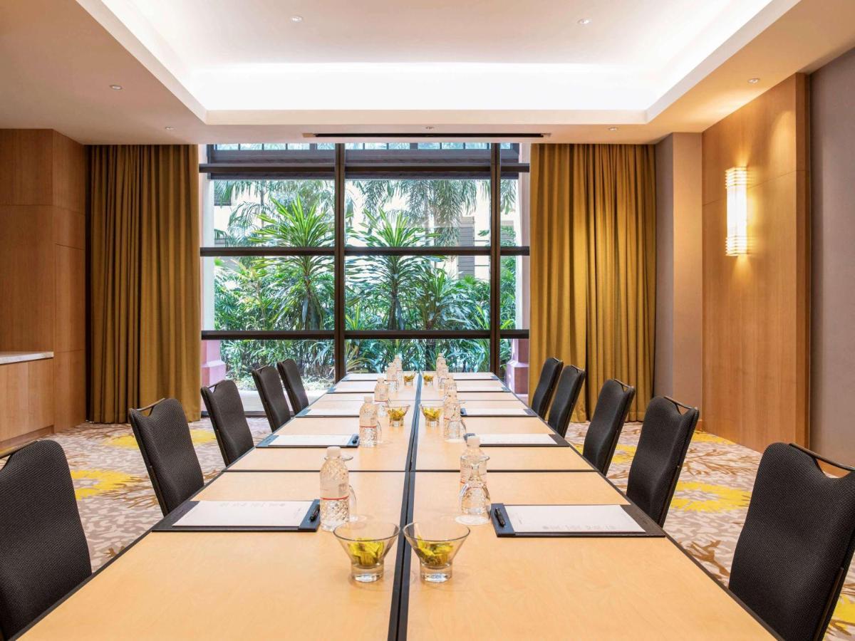 Paradox Singapore Merchant Court At Clarke Quay المظهر الخارجي الصورة The photo shows a conference room set up for a meeting. There is a long rectangular table with chairs on both sides. Each place setting has a notepad, pen, and a small glass of water. The room features large windows with plants visible outside, along
