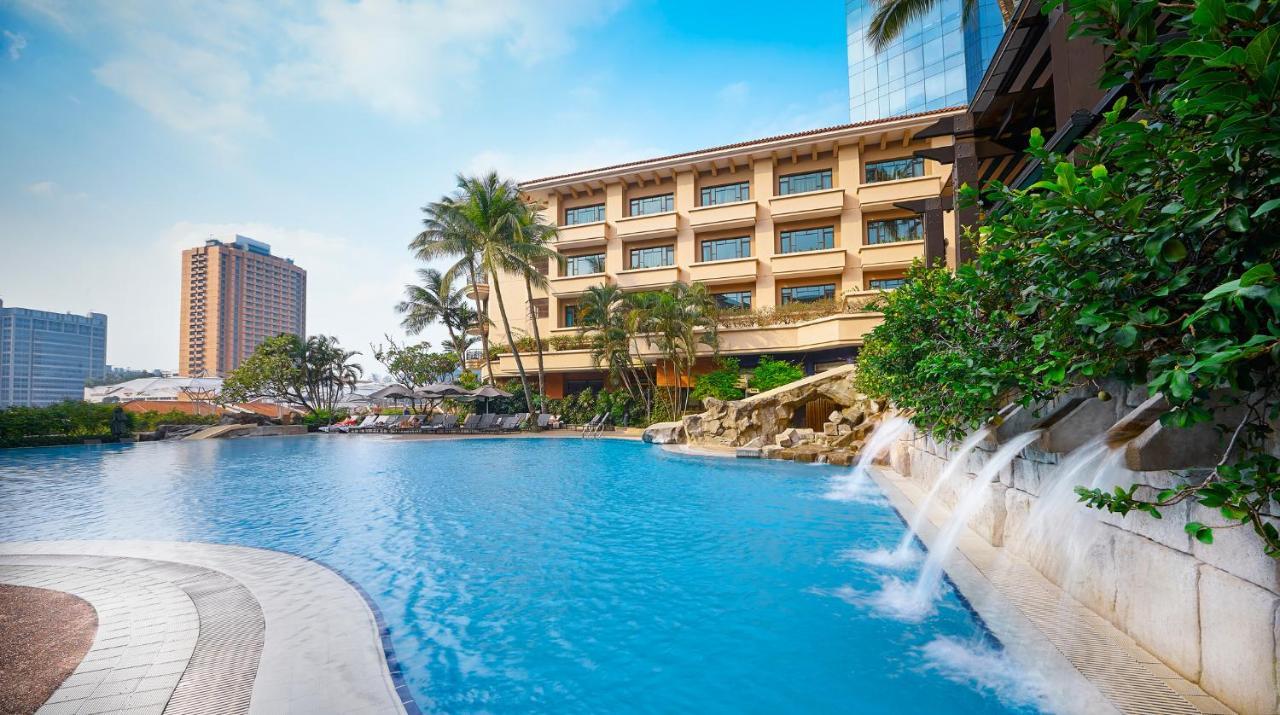 Paradox Singapore Merchant Court At Clarke Quay المظهر الخارجي الصورة The photo showcases a scenic hotel resort with a large blue swimming pool in the foreground. The pool features artificial rock formations and small waterfalls cascading gently into the water. Surrounding the pool are lush tropical plants and palm tre