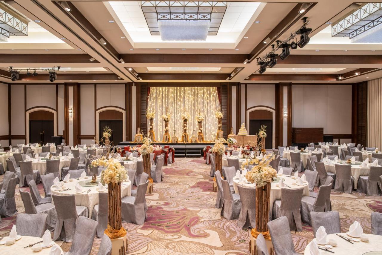 Paradox Singapore Merchant Court At Clarke Quay المظهر الخارجي الصورة The photo shows an elegantly arranged banquet or event hall. There are several round tables covered with white tablecloths and decorated with floral centerpieces, creating a sophisticated atmosphere. The chairs are covered in grey fabric, complementi