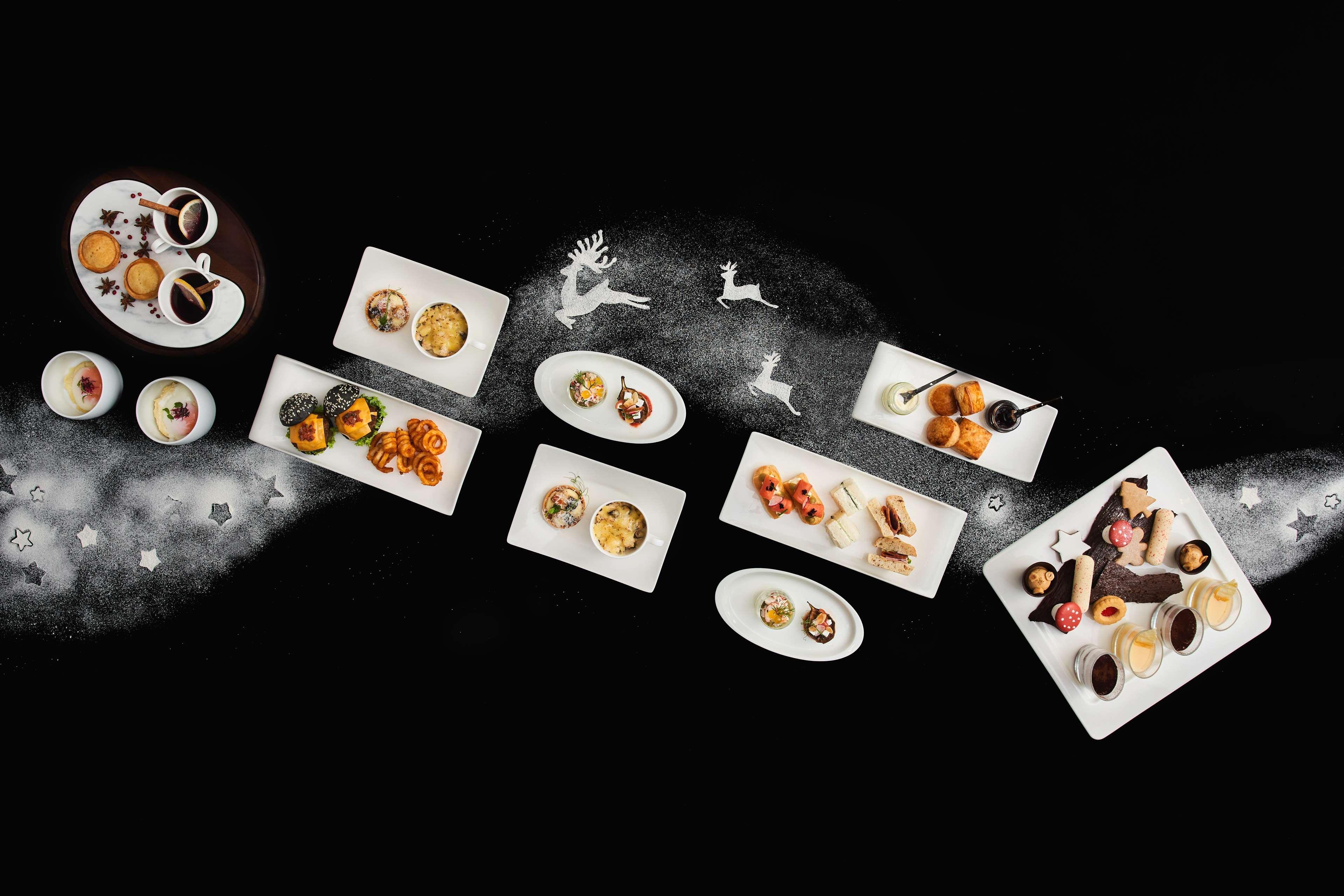 Paradox Singapore Merchant Court At Clarke Quay المظهر الخارجي الصورة The photo features an artistic arrangement of various gourmet dishes presented on white plates against a dark background. The dishes include a mix of desserts and appetizers, showcasing vibrant colors and intricate designs. Some plates contain small 