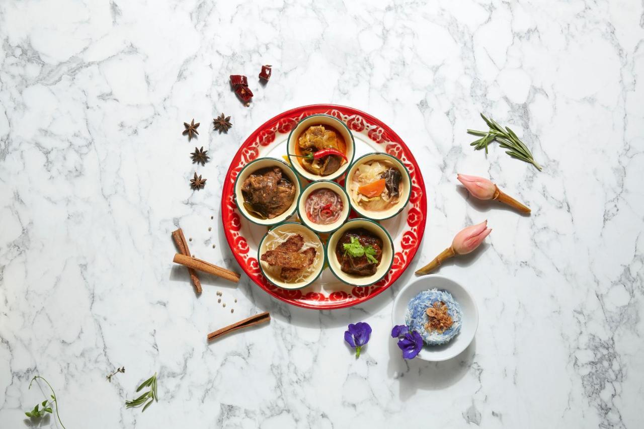 Paradox Singapore Merchant Court At Clarke Quay المظهر الخارجي الصورة The photo features a beautifully arranged plate with several small bowls containing different dishes. The plate itself has a vibrant red design, and the bowls are filled with a variety of colorful and textured foods. Surrounding the plate are some de