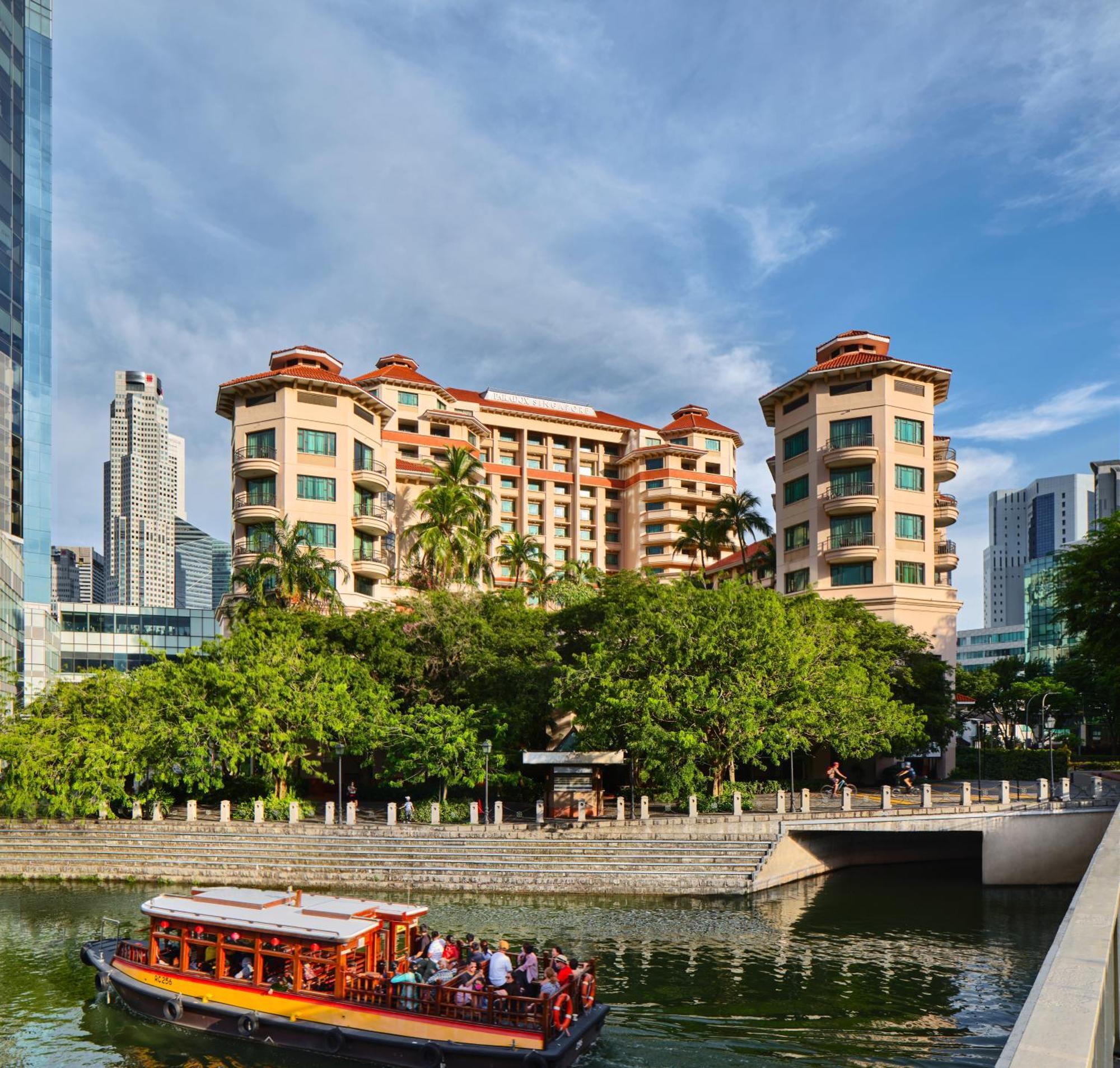 Paradox Singapore Merchant Court At Clarke Quay المظهر الخارجي الصورة The photo shows a multi-story building with a distinctive architectural style, featuring multiple balconies and a terracotta roof. It is surrounded by lush greenery, indicating landscaping that enhances the aesthetic appeal. In the foreground, there 