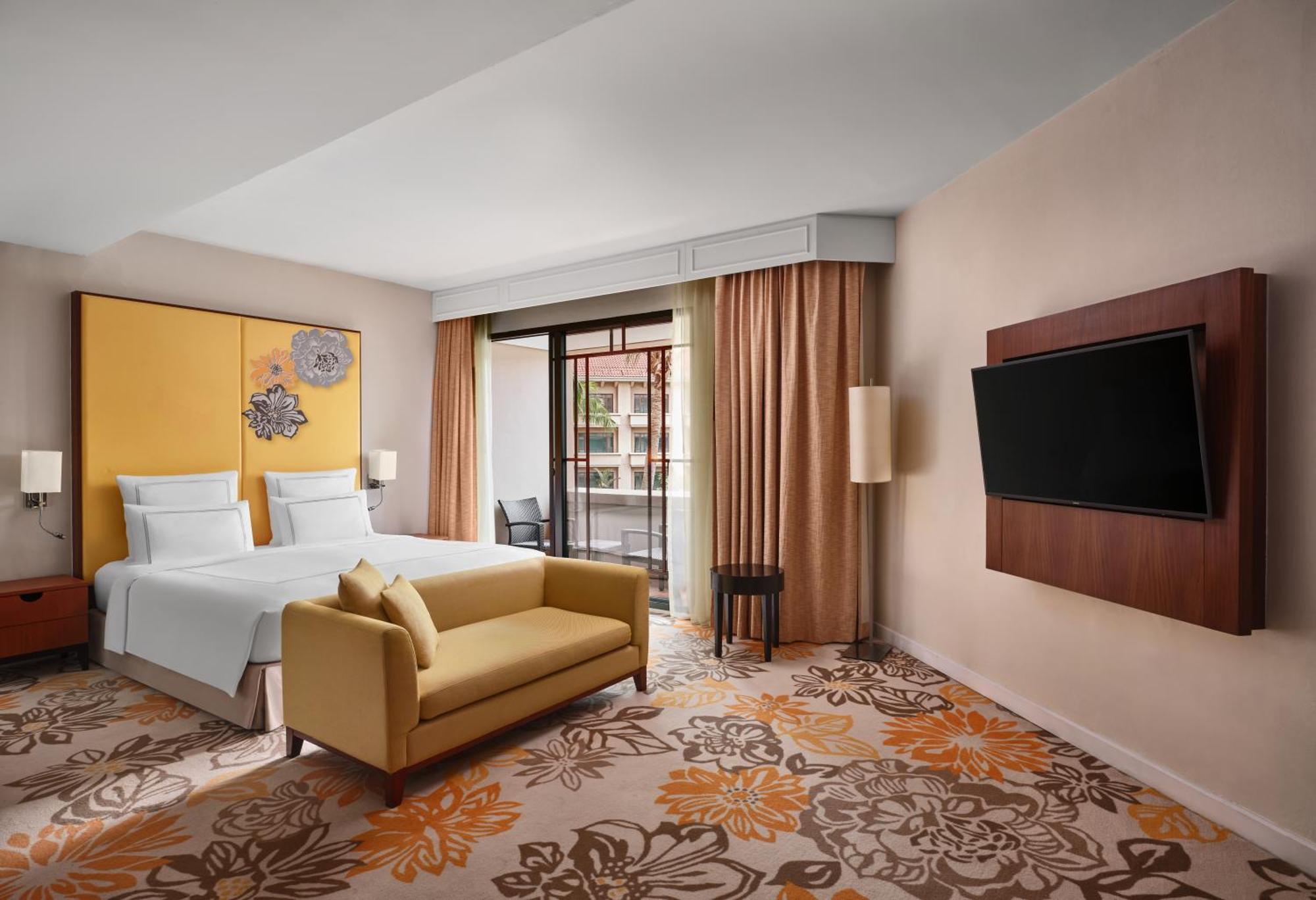 Paradox Singapore Merchant Court At Clarke Quay المظهر الخارجي الصورة The photo shows a modern hotel room featuring:

- A queen or king-sized bed with white bedding against a bright yellow wall.
- A cozy yellow sofa placed in front of the bed.
- A plush carpet with floral designs in warm colors.
- Large windows with be